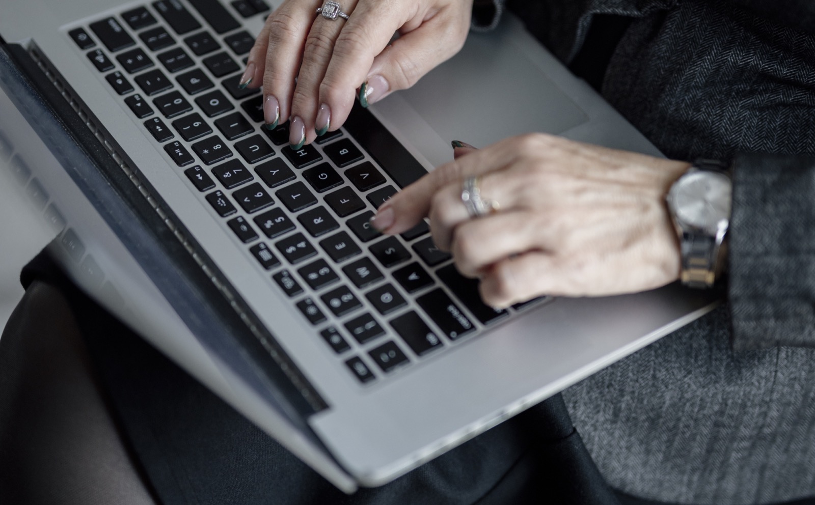 Mâini care lucrează la un laptop într-un birou