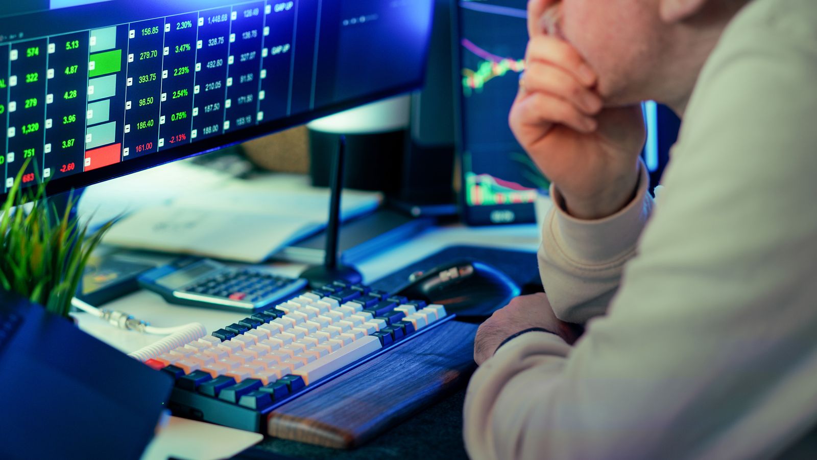Investitor care analizează date de piață pe monitoare